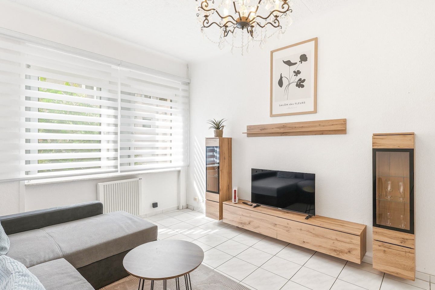 Gemütliche Sofaecke mit Kronleuchter und Medienwand