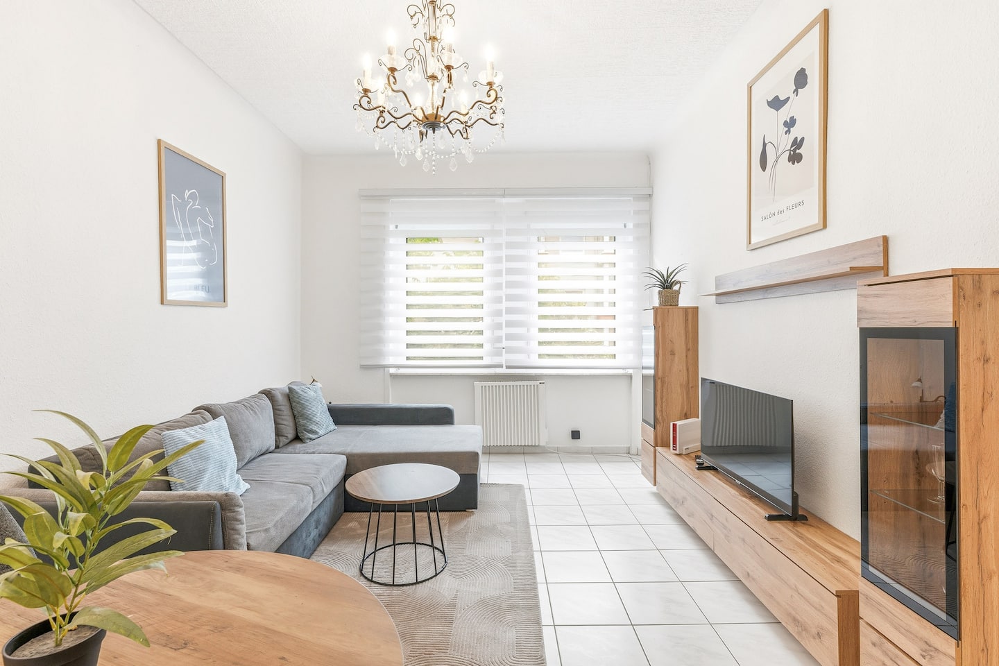 Wohnbereich mit grauem L-Sofa und TV-Wand aus Holz