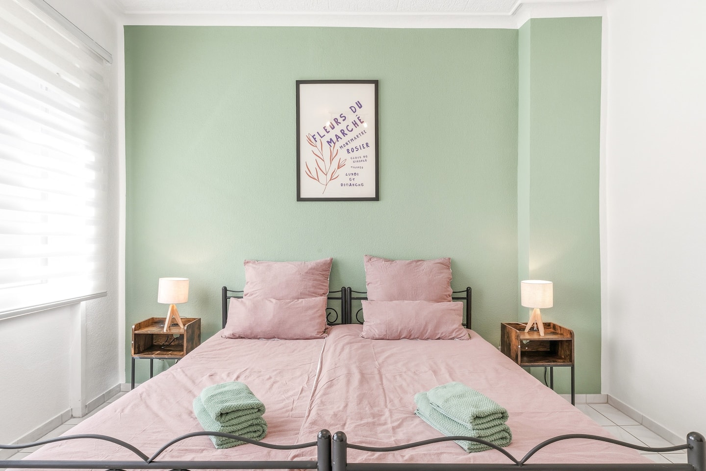 Schlafzimmer mit grüner Akzentwand und Doppelbett