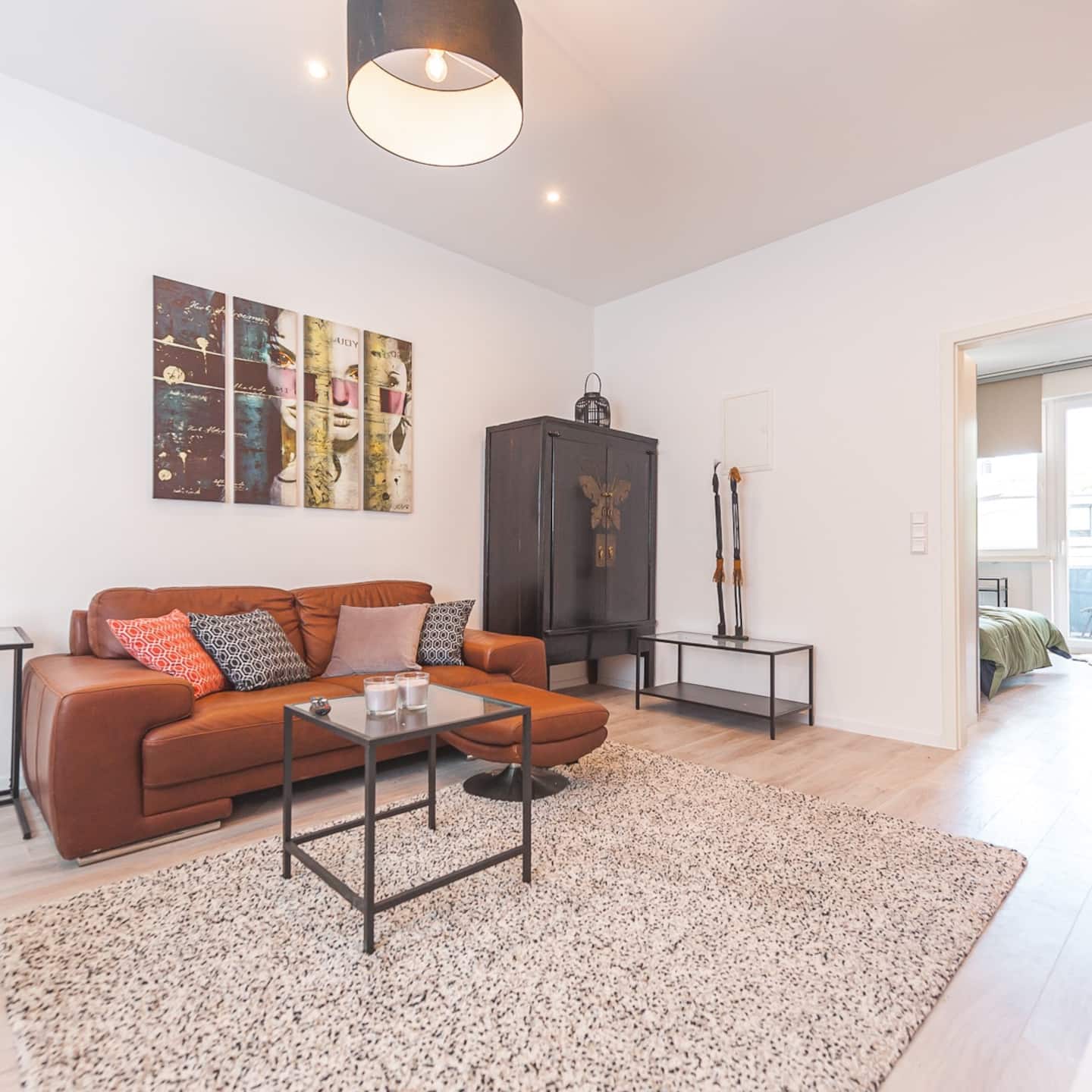 Geräumiger Wohnbereich mit Designmöbeln und Blick ins Schlafzimmer